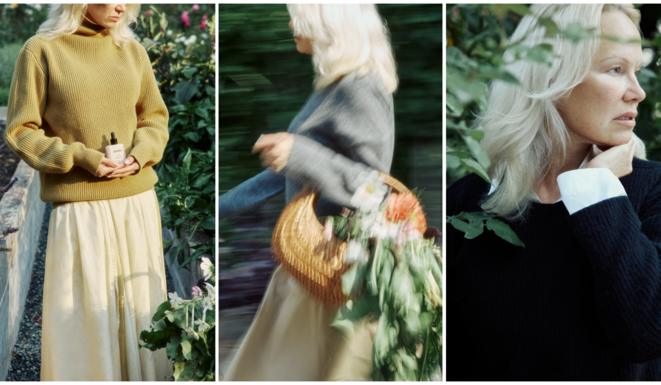 Pamela Anderson in a garden wearing a mustard sweater and holding Sonsie Skin skin care; walking with a flower-filled basket; close-up profile showing bare, natural skin.