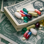 Employer, Pharmacy Advocates Applaud DOL Final Rule on PBMs close-up studio macro shot of various pills on US dollar bills.